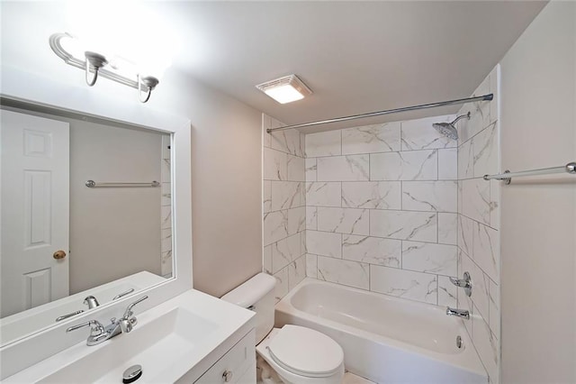 full bathroom featuring tiled shower / bath, vanity, and toilet