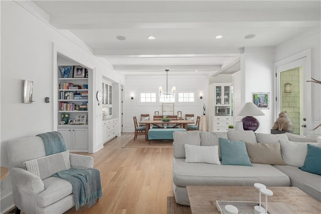 living room featuring an inviting chandelier, beam ceiling, recessed lighting, and light wood-style flooring