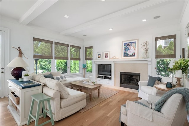 living room featuring recessed lighting, beamed ceiling, light wood-style floors, and a high end fireplace