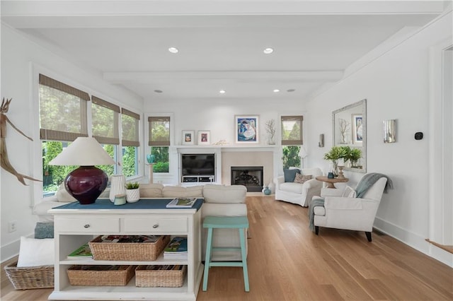 living area with light wood-type flooring, baseboards, beam ceiling, and a fireplace