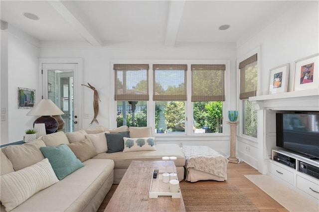 living area with baseboards and beamed ceiling