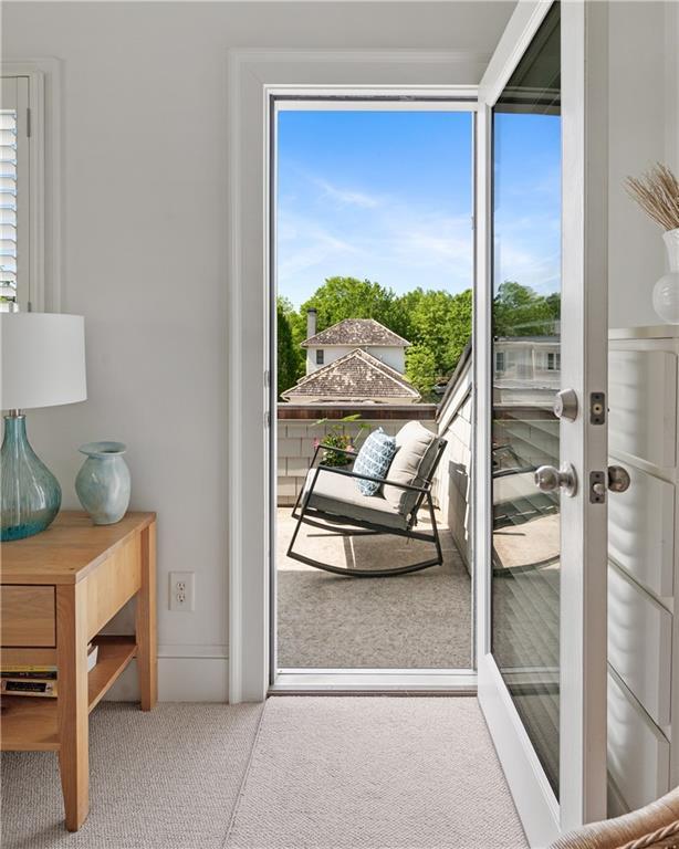 doorway to outside with plenty of natural light and carpet