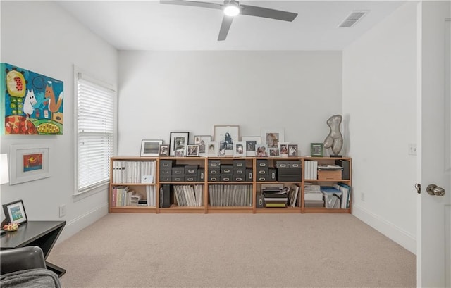 interior space with visible vents, a ceiling fan, carpet, and a healthy amount of sunlight