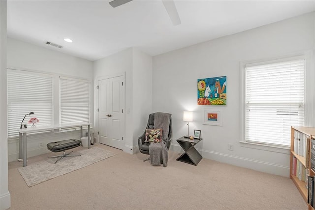 interior space with light colored carpet, a ceiling fan, baseboards, and visible vents