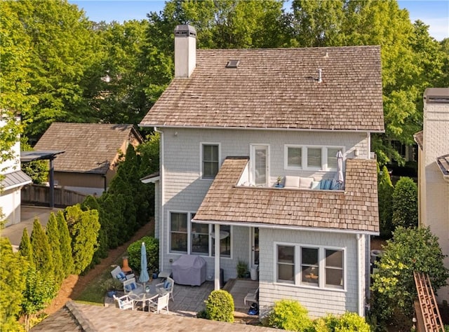 rear view of property featuring a patio and a chimney