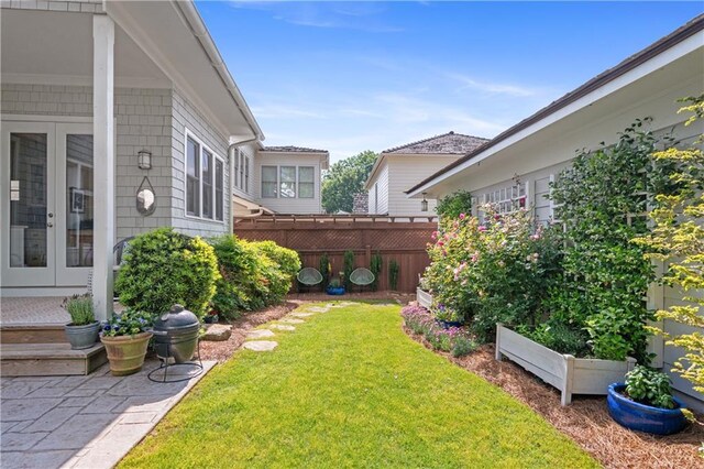 view of yard featuring french doors and fence