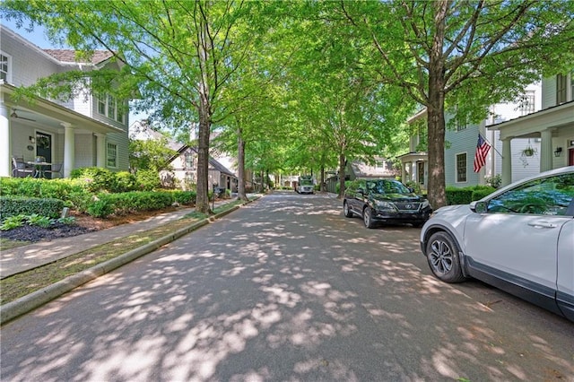 view of street with a residential view, sidewalks, and curbs