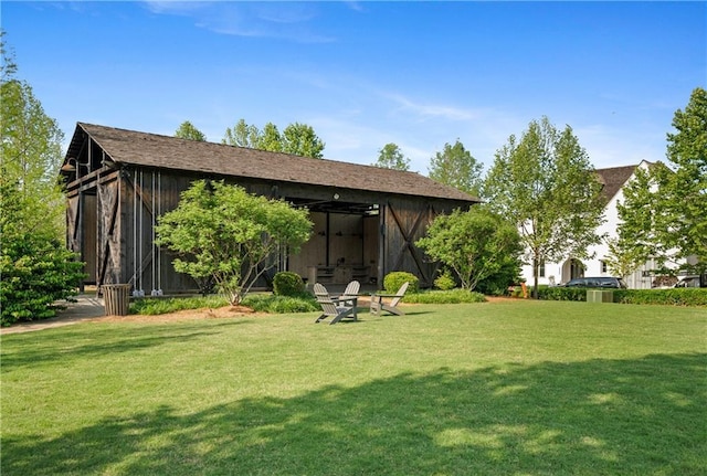 rear view of house with an outbuilding, an outdoor structure, and a yard