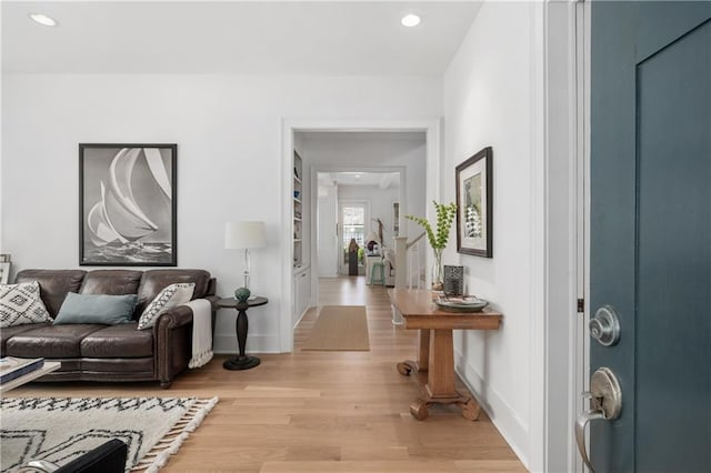 living room with baseboards, recessed lighting, and light wood-style flooring