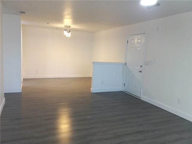 unfurnished room with dark wood-type flooring