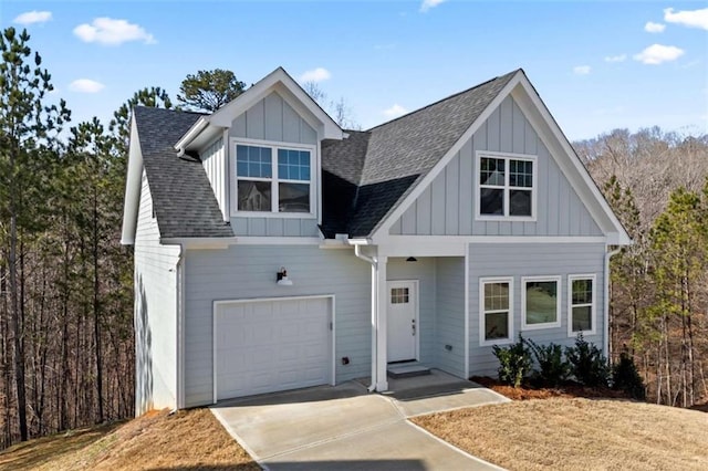 view of front of property featuring board and batten siding, roof with shingles, driveway, and a garage