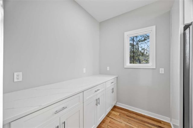 interior space featuring light wood finished floors and baseboards