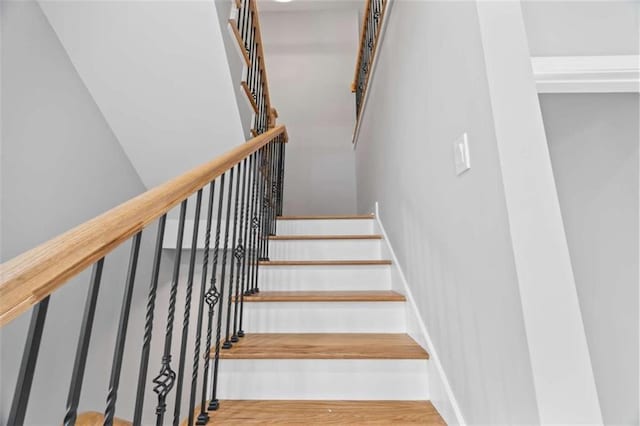 stairway featuring wood finished floors and baseboards