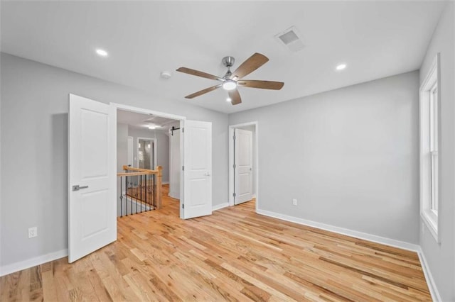 unfurnished bedroom featuring a ceiling fan, light wood-type flooring, visible vents, and baseboards