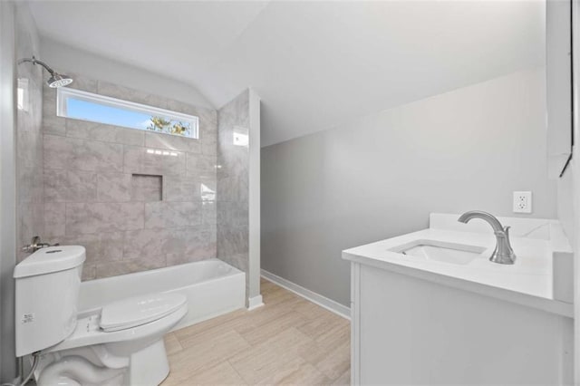 full bath with baseboards, toilet, lofted ceiling, vanity, and shower / washtub combination