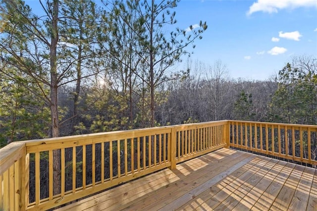 wooden terrace featuring a wooded view