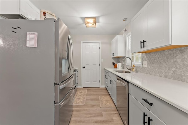 153 Garrison Dr, Cleveland, GA 30528 - kitchen with appliances with stainless steel finishes, a sink, light wood-type flooring, backsplash, and light countertops