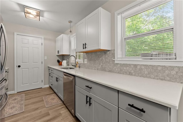 153 Garrison Dr, Cleveland, GA 30528 - kitchen with a sink, appliances with stainless steel finishes, light wood-style flooring, tasteful backsplash, and light countertops
