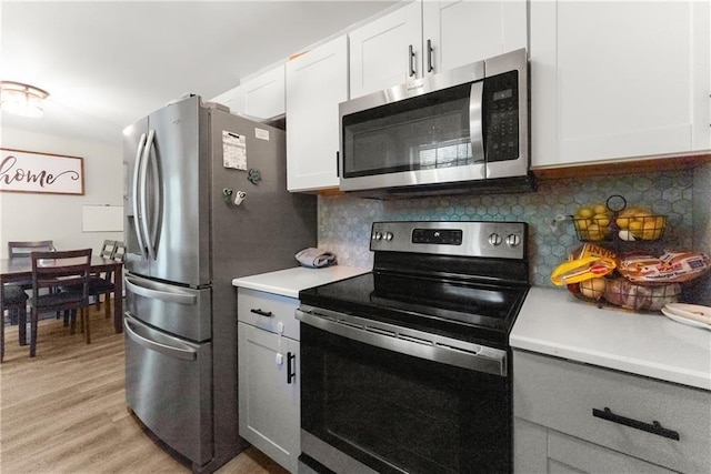 153 Garrison Dr, Cleveland, GA 30528 - kitchen featuring appliances with stainless steel finishes, light countertops, light wood-style floors, and decorative backsplash