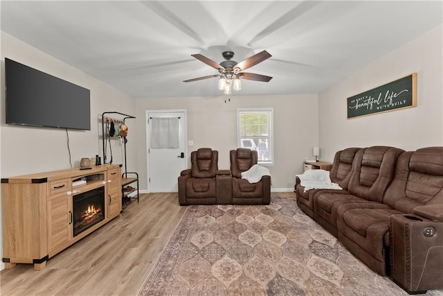 153 Garrison Dr, Cleveland, GA 30528 - living room featuring ceiling fan, light wood-style flooring, a glass covered fireplace, and baseboards