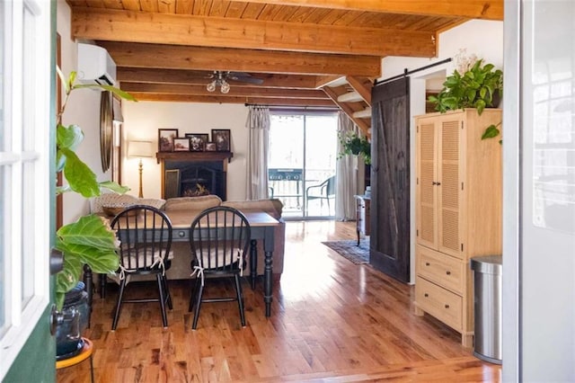 dining area with a wall mounted AC, beam ceiling, a fireplace, a barn door, and wooden ceiling