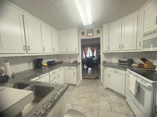 3484 Lynley Mill Ln, Dacula, GA 30019 - kitchen featuring white appliances, white cabinetry, dark countertops, decorative backsplash, and a textured ceiling