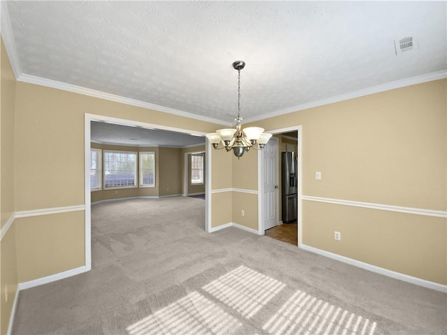 unfurnished room with crown molding, a notable chandelier, carpet flooring, a textured ceiling, and baseboards