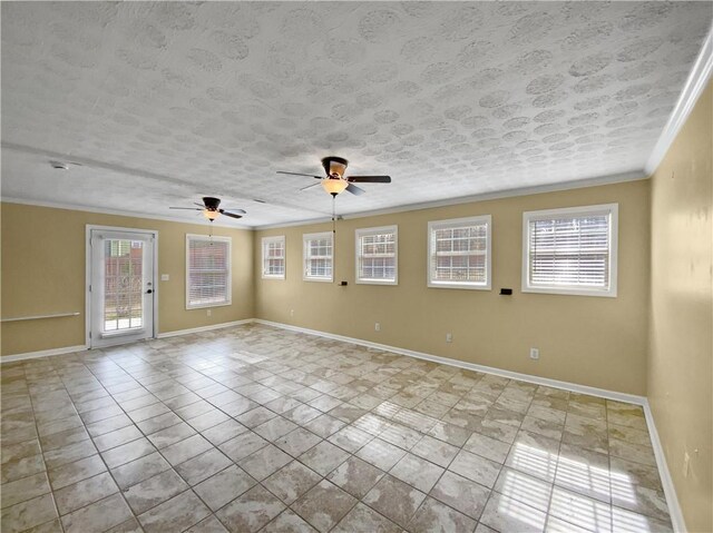 empty room featuring ornamental molding, a healthy amount of sunlight, a textured ceiling, and baseboards