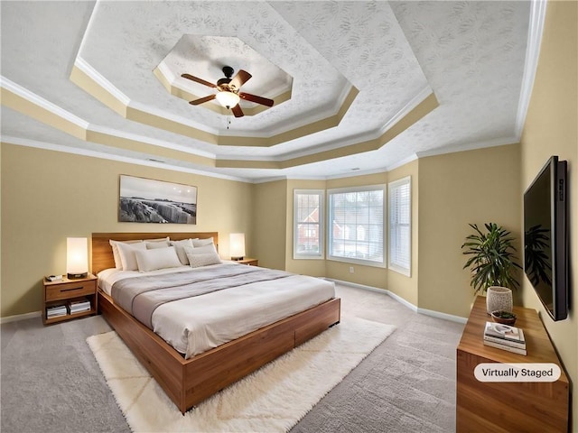bedroom with light carpet, baseboards, ceiling fan, ornamental molding, and a tray ceiling