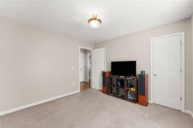 bedroom with carpet flooring, baseboards, and a textured ceiling