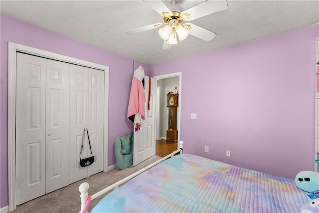 bedroom with a closet, a textured ceiling, ceiling fan, and carpet flooring