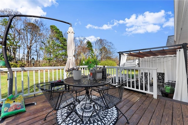 deck with outdoor dining area, a yard, and a pergola