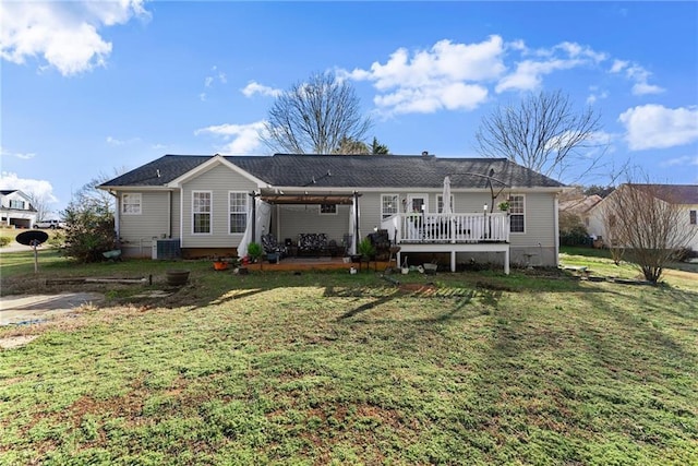 rear view of property featuring a wooden deck, a yard, and central AC