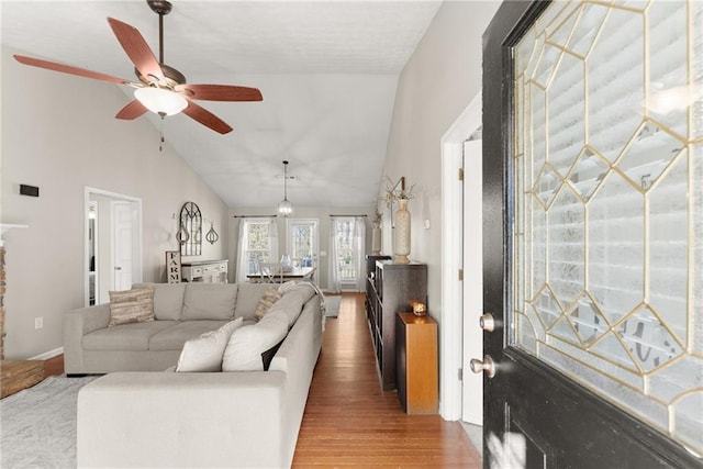 living area featuring ceiling fan, high vaulted ceiling, and wood finished floors