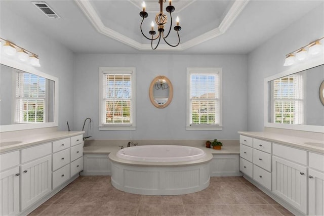 bathroom featuring a tray ceiling, visible vents, and plenty of natural light