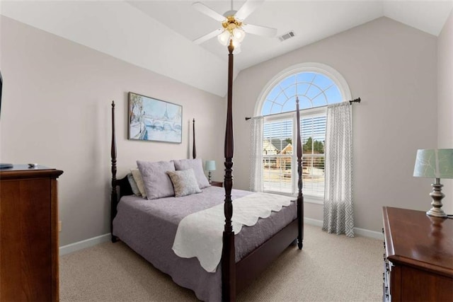 bedroom with lofted ceiling, light colored carpet, visible vents, and baseboards