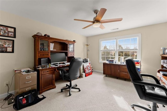 office area featuring a ceiling fan, light carpet, visible vents, and baseboards