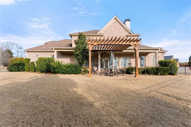 rear view of house featuring brick siding, fence, a patio, and a pergola