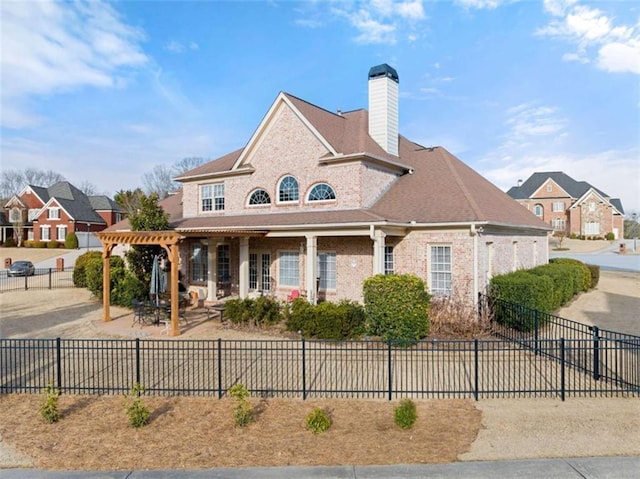 view of front of house featuring fence private yard, a chimney, a patio, and brick siding