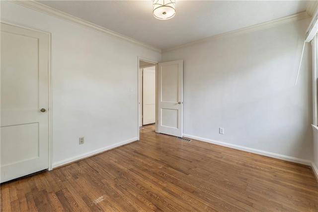 unfurnished room with wood finished floors, baseboards, and crown molding