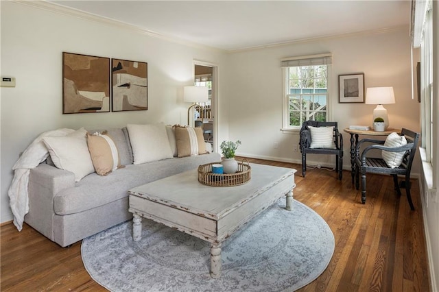 living area featuring ornamental molding, wood finished floors, and baseboards