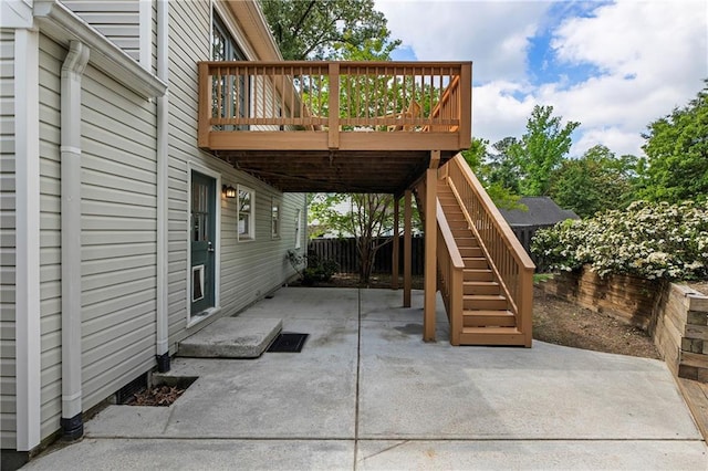 view of patio / terrace featuring a wooden deck, fence, and stairs