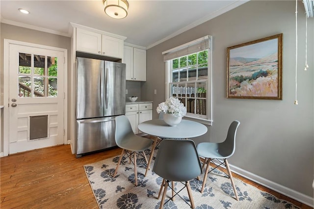 dining space with crown molding, light wood-style floors, baseboards, and recessed lighting