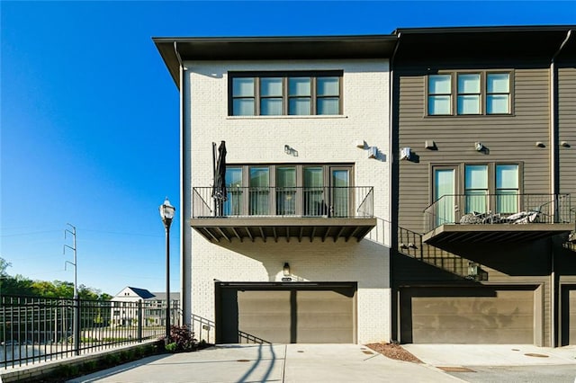 6666 Sterling Dr, Sandy Springs, GA 30328 - rear view of house featuring a garage, brick siding, fence, and a balcony