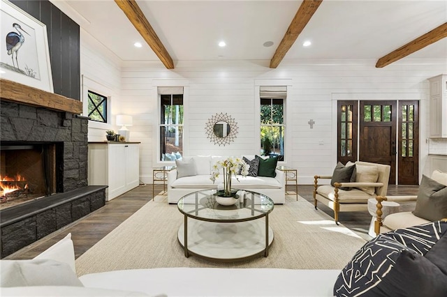 living room featuring beamed ceiling, plenty of natural light, and a fireplace