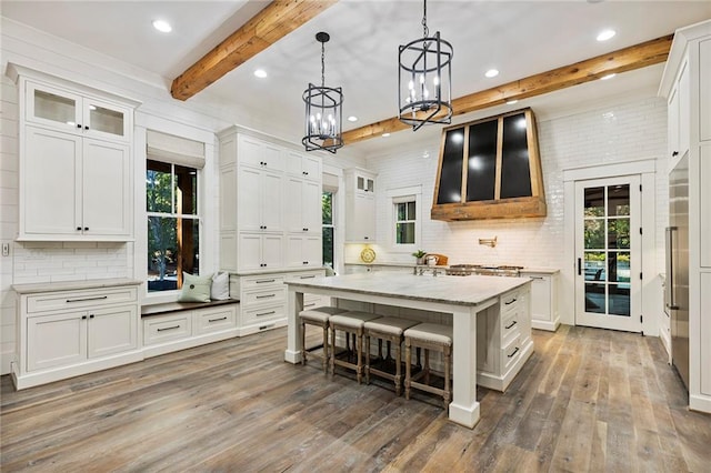 kitchen featuring beamed ceiling, a kitchen island, white cabinets, and dark hardwood / wood-style flooring