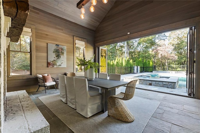 sunroom with wooden ceiling, vaulted ceiling, and a wealth of natural light