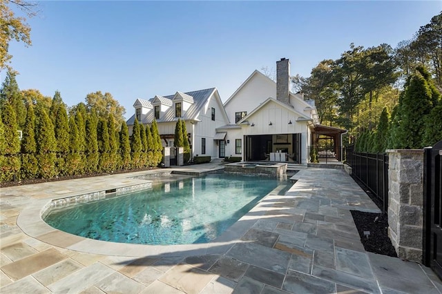 view of swimming pool featuring an in ground hot tub and a patio area