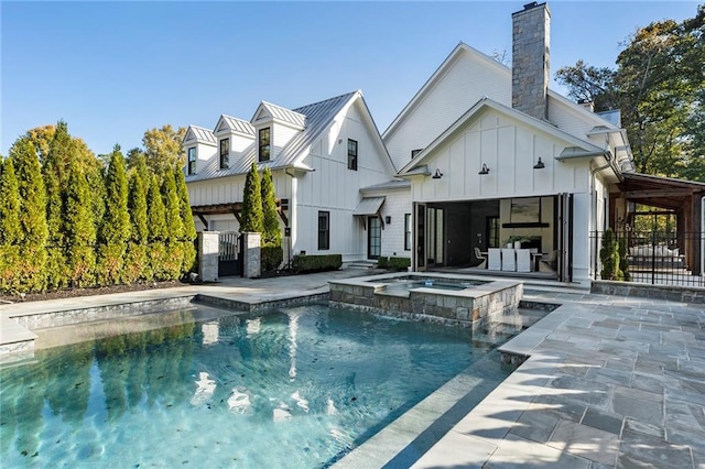 back of house featuring a patio and a pool with hot tub