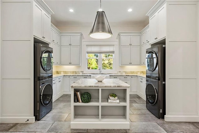 laundry area featuring stacked washer / drying machine and sink